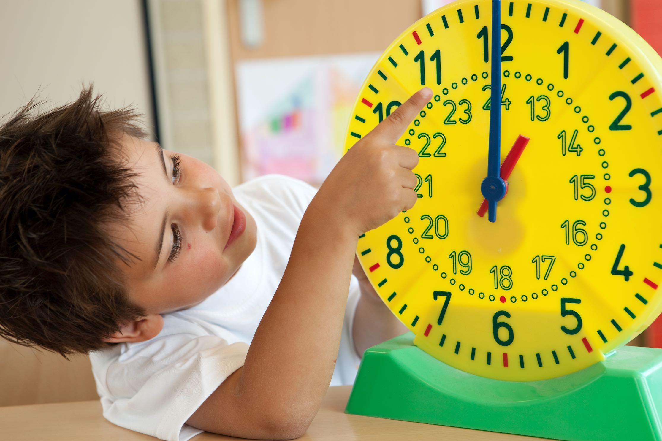 boy playing with plastic clock