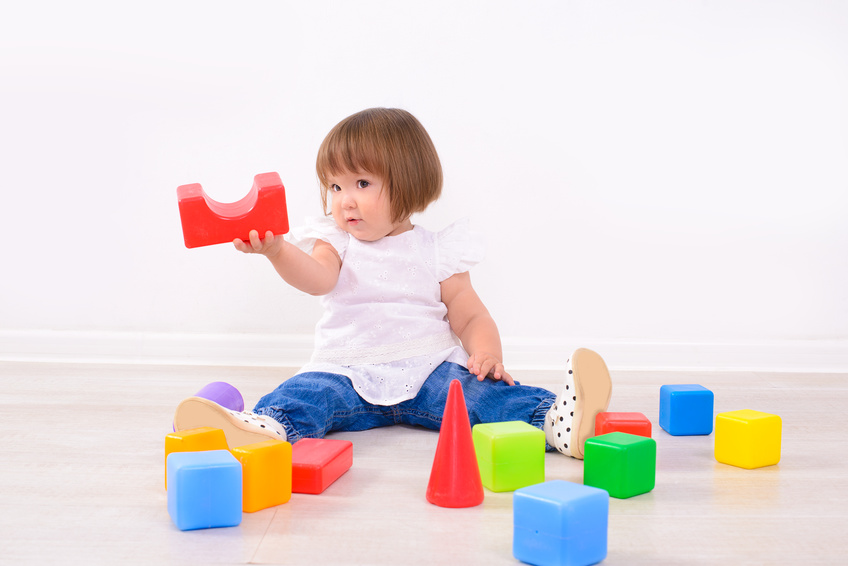 toddler playing with different shape blocks