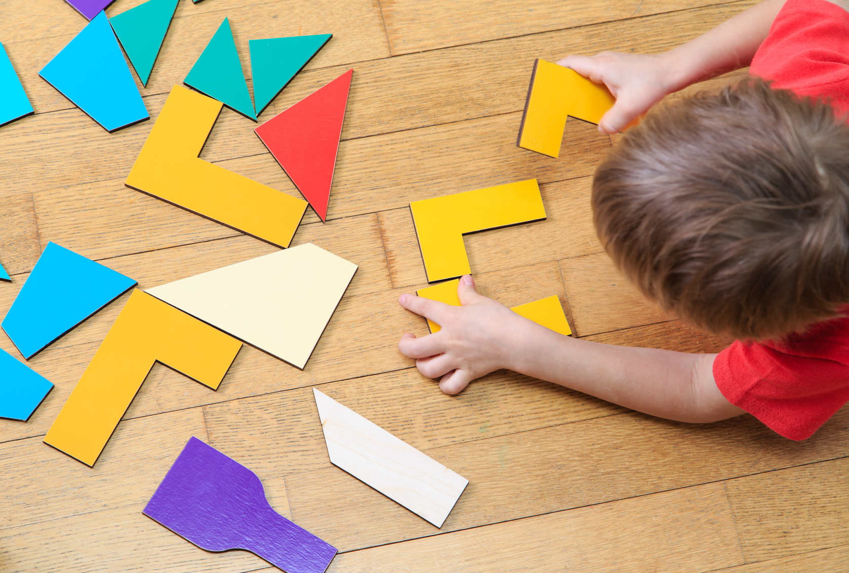 child playing with shapes on floor